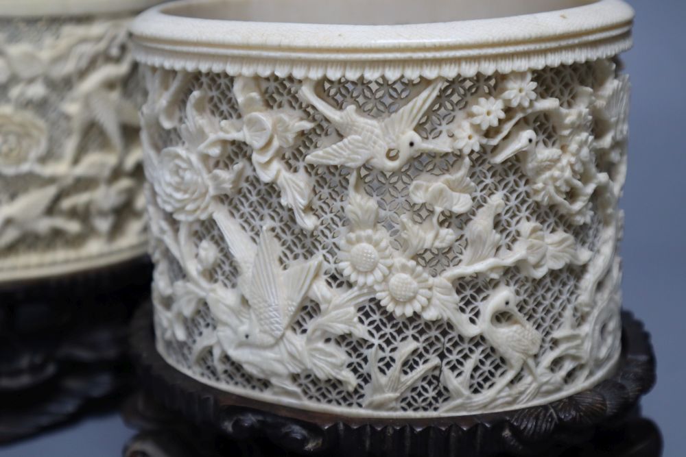 A pair of early 20th century Chinese ivory pots, with carved wood stands, overall height 16cm